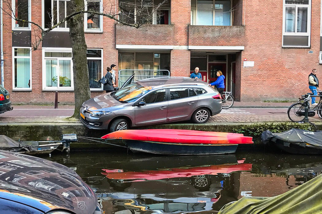 Auto ist beim Parken in Amsterdam am Kanal zu dicht an den Rand gefahren