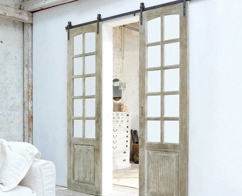 Doppelschiebetür aus Holz mit Glaselementen an schwarzer Schiene
