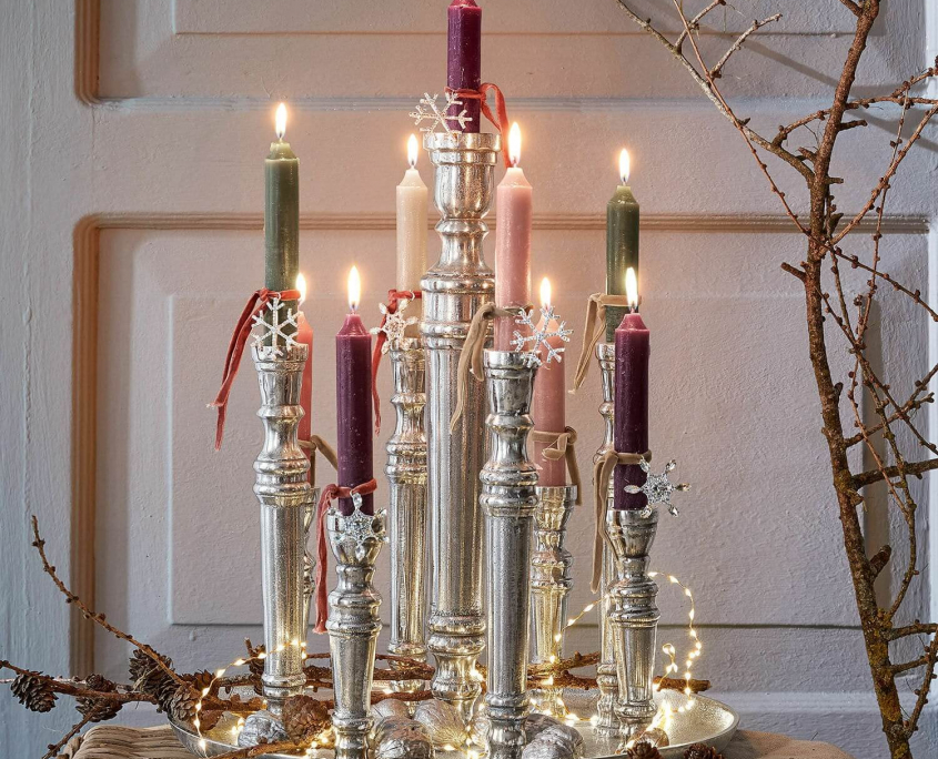 Shabby Chic Deko mit silbernen Kerzenleuchtern auf einem Silbertablett und Kerzen in Rose- und Grüntönen