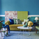 Fehlkäufe beim Möbelkauf vermeiden: Sofa mit verschiedenen Materialien und Farbmustern an der Wand und verschiedenen Kissen und Sesseln zur Auswahl