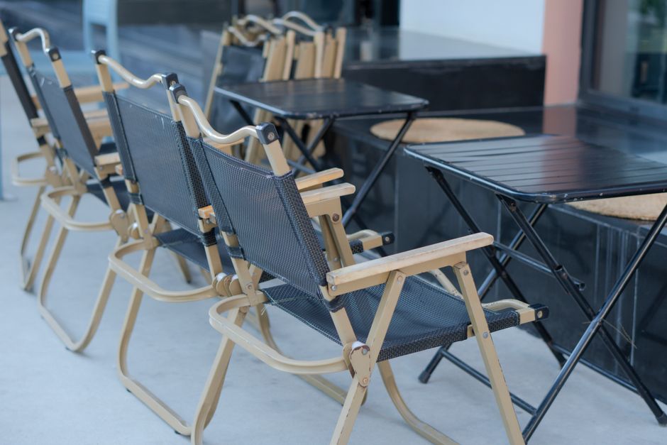 Narrow balcony with a wall-mounted folding table and two folded chairs stored against the wall and a small herb box, balkon möbel
